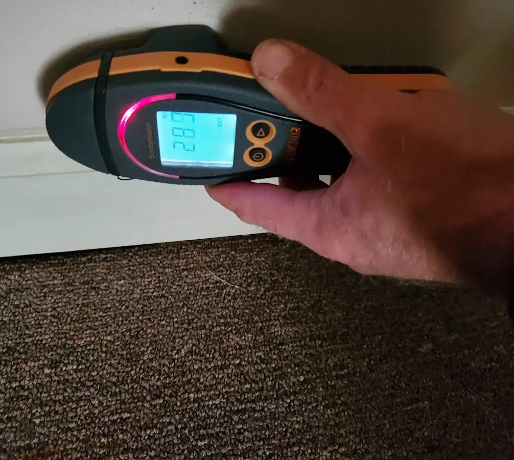 Moisture detection at baseboard during Storm Damage Restoration in Hampton